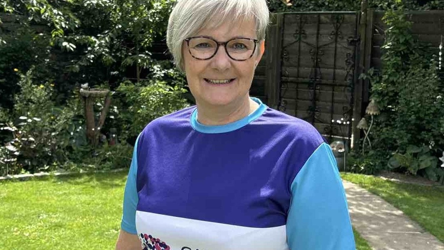 Velda in running top with Cancer Research UK logo