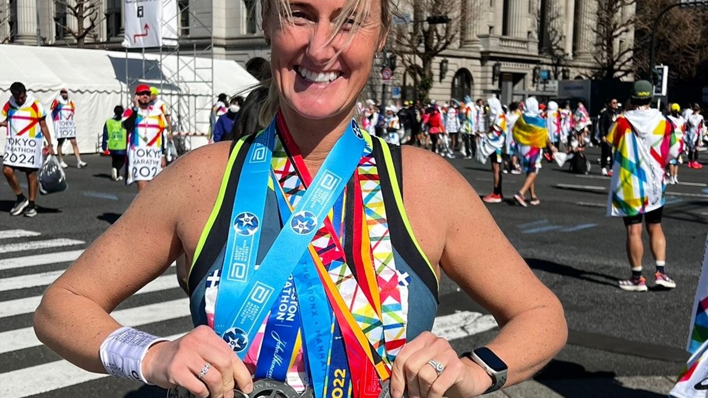 Lyn holding some of the medals she has received from marathons