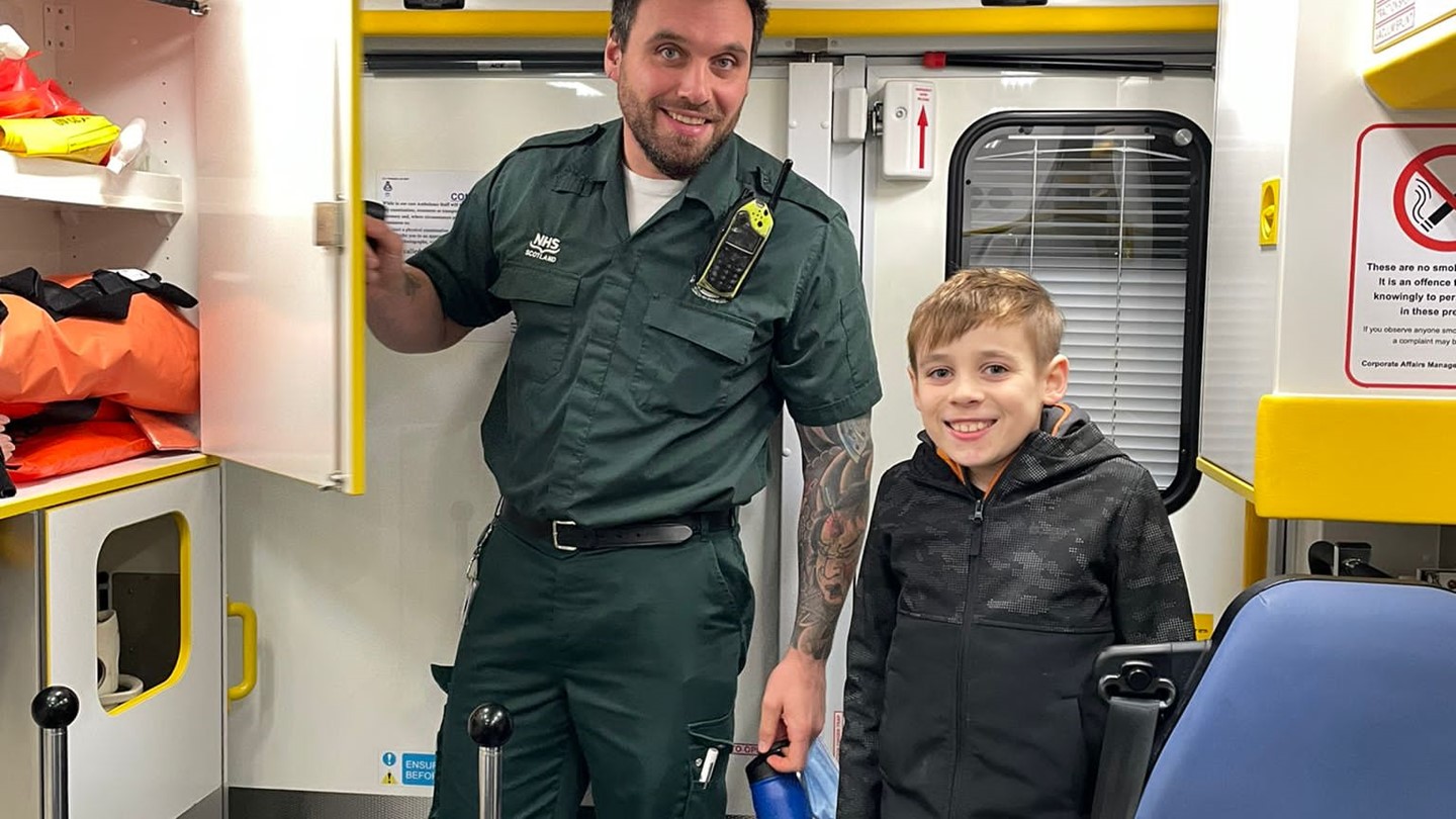 Calum with his son, in uniform in ambulance