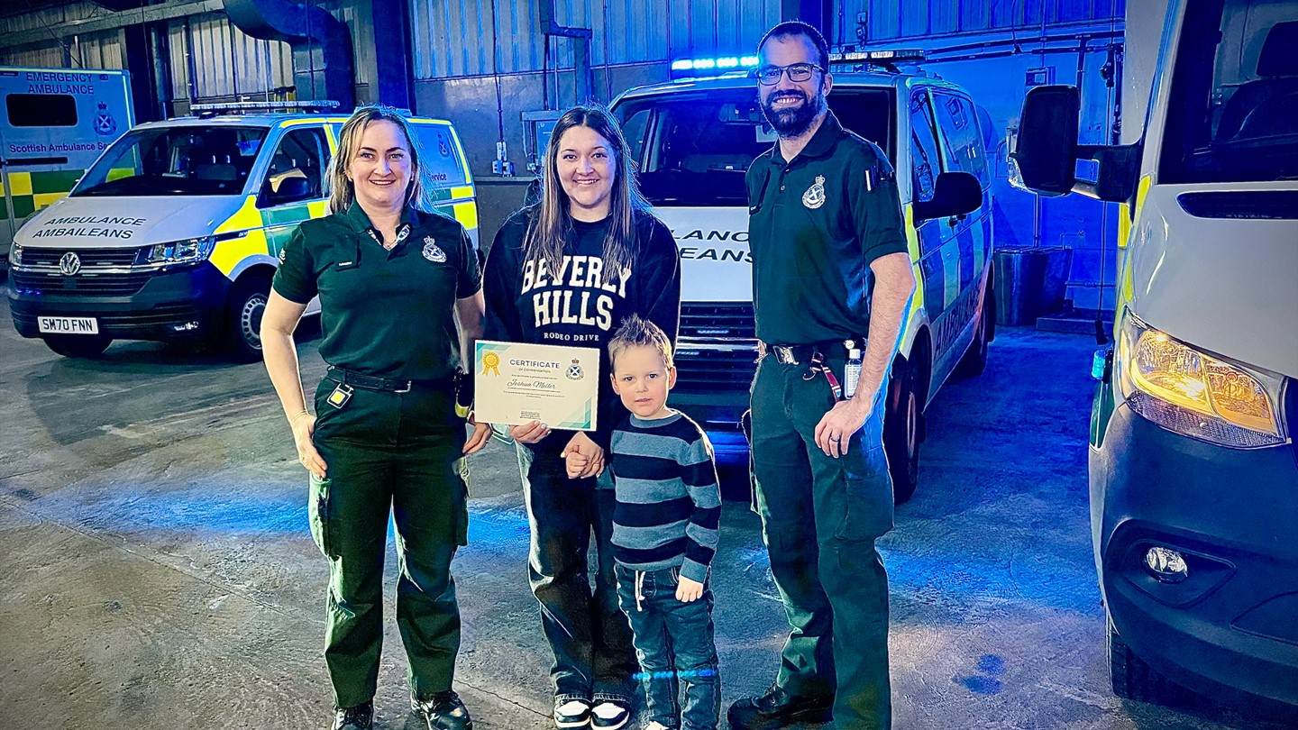 Brave Joshua stands proud with his certificate with his mum and the crew watching on